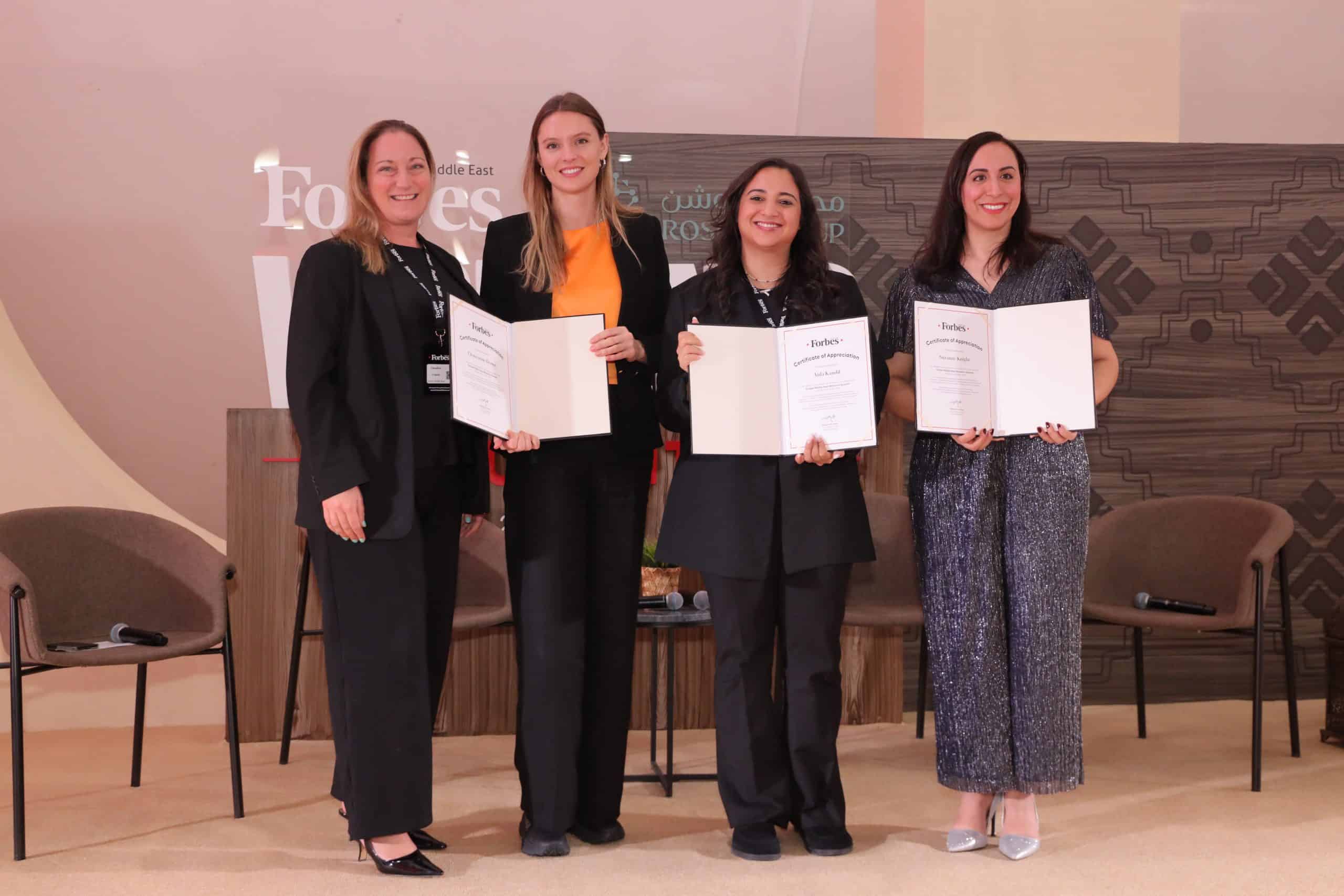 Suzanne Knight with three women holding awards at a conference.