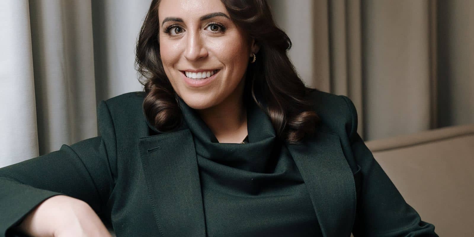 Portrait of Suzanne Knight smiling in a dark green suit