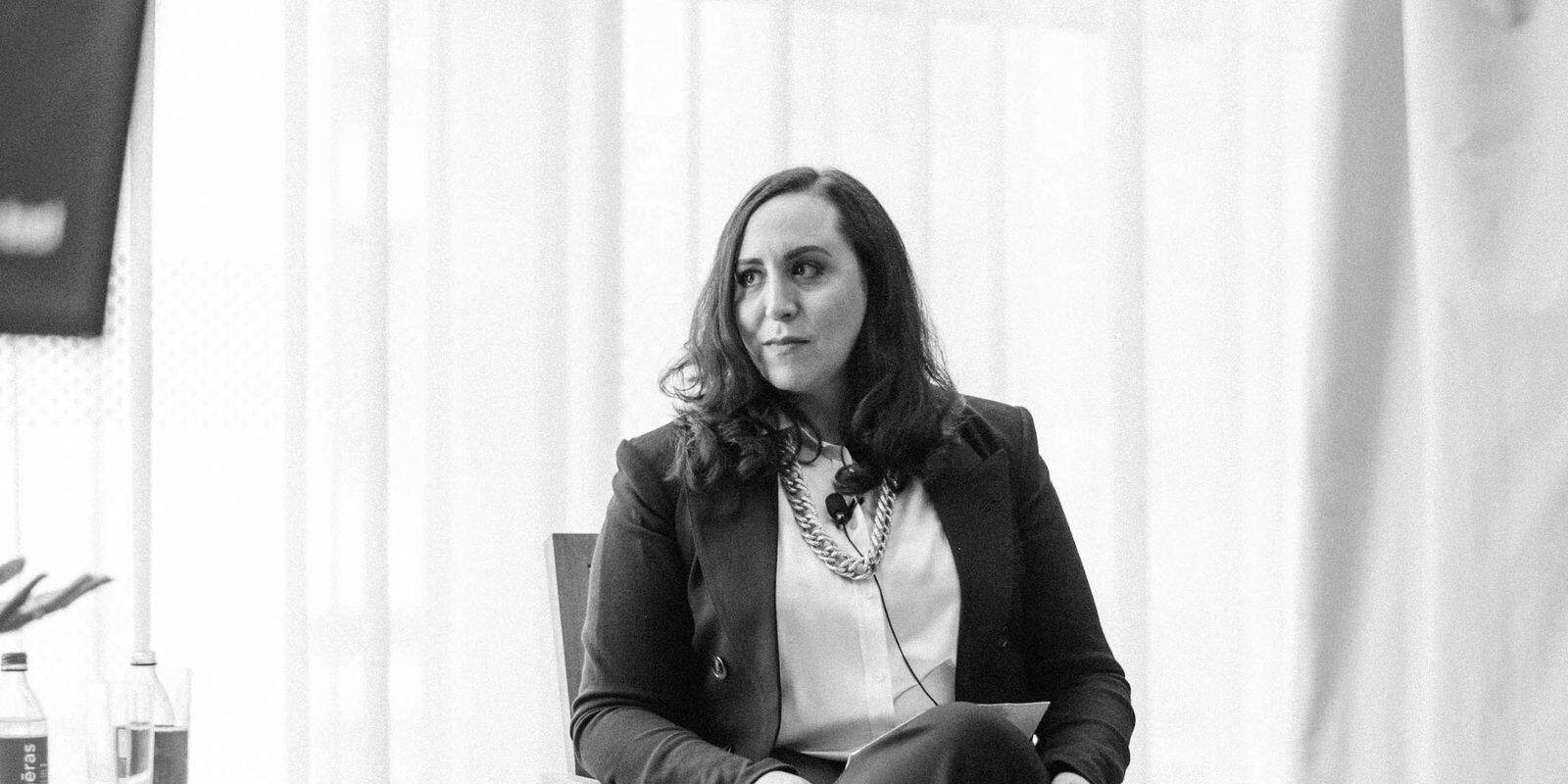 Black and white photo of Suzanne Knight seated on a leadership panel