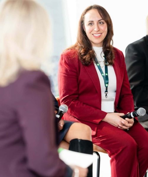 Suzanne Knight seated and holding a microphone during a panel discussion or fireside chat, in conversation with an interviewer.